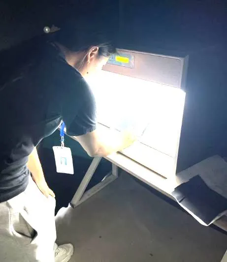 Technician checking fabric on a light box